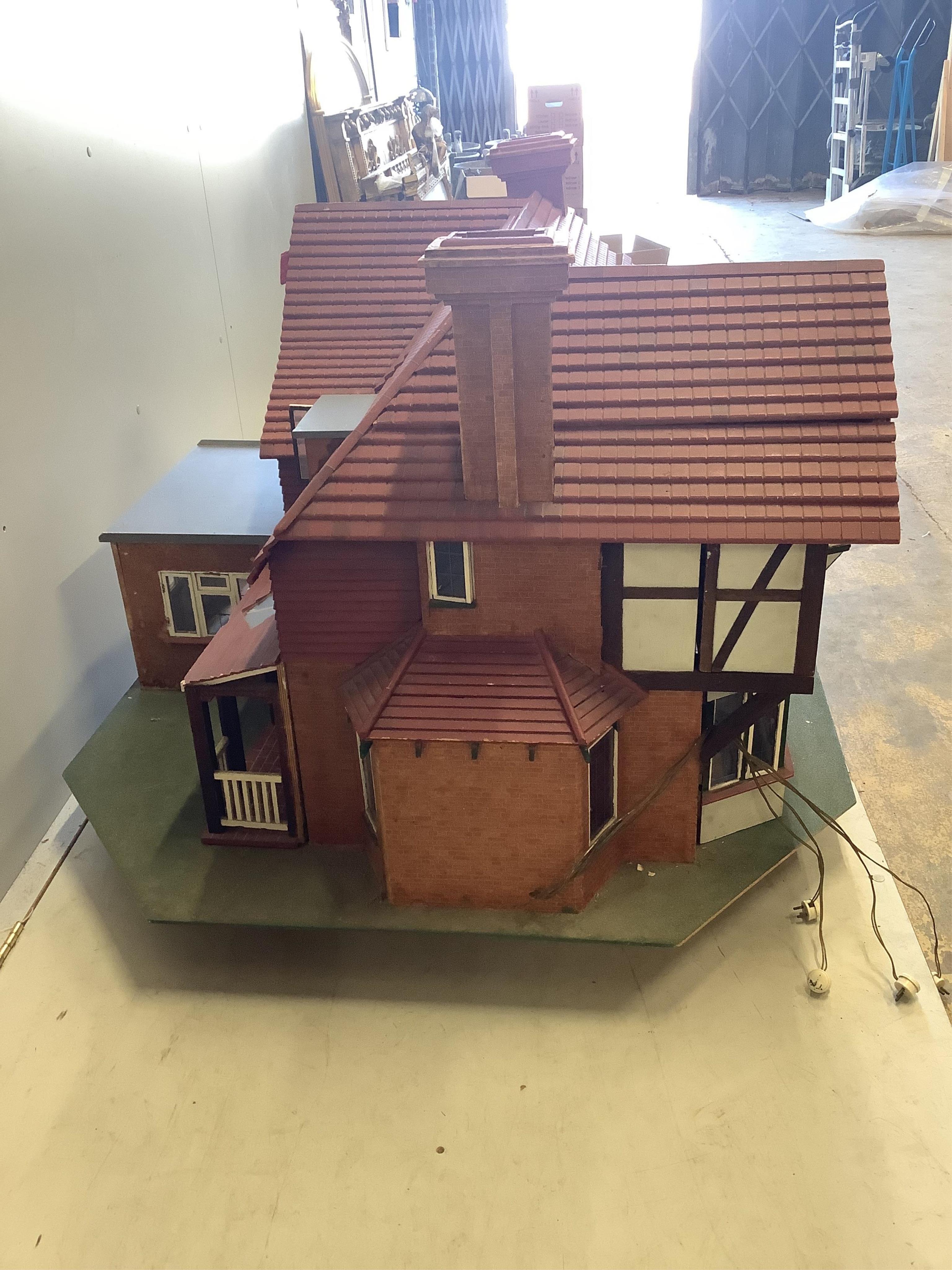 A mid 20th century scratch built mock Tudor doll’s house with some accessories, width 120cm, height 76cm. Condition fair.